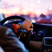 Chauffeur élégant au volant d'une voiture VTC au crépuscule